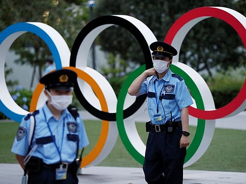 Security officers stand guard next to Olympic Rings monument during an anti-Olympics rally outside the Japan Olympic Committee (JOC) headquarters near the National Stadium, the main stadium for the 2020 Tokyo Olympic Games, in Tokyo.