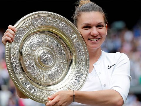 Romania's Simona Halep poses with the trophy as she celebrates after winning the Wimbledon final against Serena Williams of the U.S.