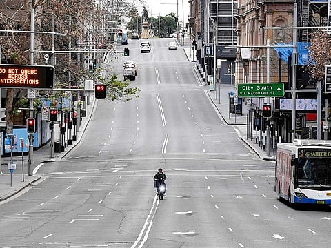 A food delivery worker rides in the central business district of Sydney on June 26, 2021, as Australia's largest city entered a two-week lockdown to contain an outbreak of the highly contagious Delta variant.