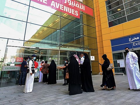 Kuwaiti employees supervise as mall workers verify their vaccination certificates before allowing entry to The Avenues Mall in Kuwait City.