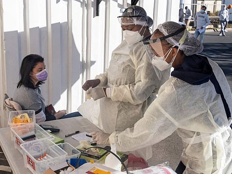 Health workers prepare to test a woman for COVID-19 at the Fourways Life Hospital in Johannesburg on June 28, 2021.