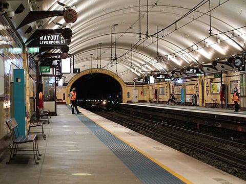 Transport workers stand on mostly deserted train platforms at morning commute hour in the city centre during a lockdown in Sydney, Australia, June 28, 2021