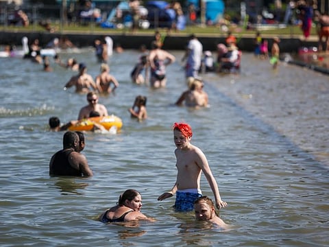 People try to beat the heat at a beach in Chestermere, Alberta, on June 29, 2021. Environment Canada warned the torrid heatwave that has settled over much of Western Canada won't lift for days.