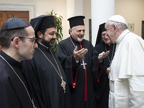 This handout picture taken and released by the Vatican Media on July 1 shows Pope Francis with he Patriarch of Antioch and All the East for the Syriac Catholic Church, Ignatius Youssef III Younan (centre), one of Lebanon's Christian leaders during a meeting at the Altar of Confession in Saint Peter Basilica in the Vatican.