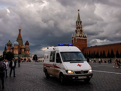 A picture taken on July 1, 2021 shows an ambulance driving across Red Square with the St. Basil's Cathedral (L) and Kremlin's Spasskaya Tower (R) in the background.