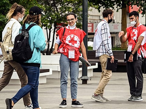 Russian Red Cross volunteers talk to people in central Moscow on July 3, 2021 as Russia reported 697 Covid-19 deaths in the previous 24 hours, the fifth straight day the country has set a new record as it battles the surging Delta variant.