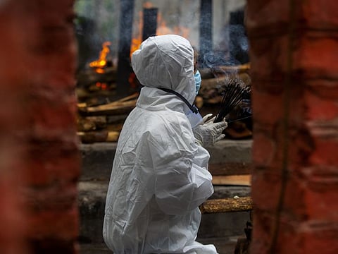 A relative performs final rituals before the cremation of a COVID-19 victim in Guwahati, India.