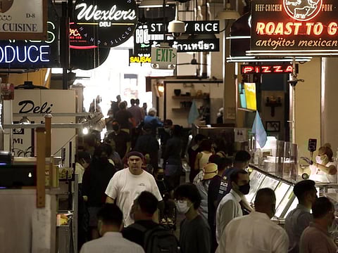 People, many masked, look for lunch at the Grand Central Market on the first day that California reopened its economy in downtown Los Angeles on June 15, 2021.