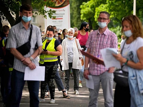 In this July 2, 2021, file photo, people wait in line to get a coronavirus vaccine at a vaccination centre at VDNKh (The Exhibition of Achievements of National Economy) in Moscow, Russia.