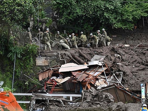 Members of Japan's Self-Defense Forces sift through mud and debris as they search for missing people at the scene of a landslide in Atami, Shizuoka Prefecture.