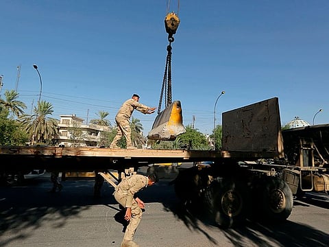 Iraqi security forces remove a concrete barrier in Baghdad, Iraq, Sunday, July 4, 2021.