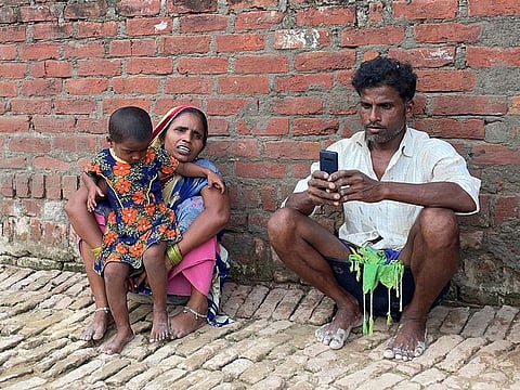 Asha Devi, 35, a mother of five who is a labour worker, sits along with her husband and their daughter outside her one-room house in Dihwa village in the northern state of Uttar Pradesh.