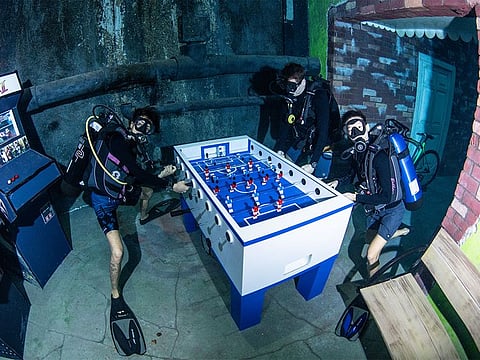 Divers playing foosball under water