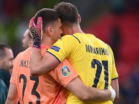 Spain's goalkeeper Unai Simon and Italy's goalkeeper Gianluigi Donnarumma embrace each other before the penalty shootout