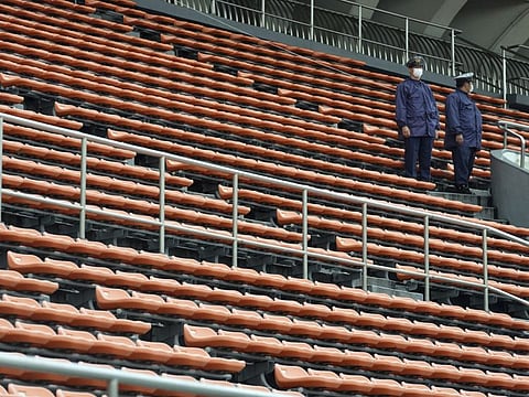 Police officers stand guard at empty seats of the grandstand during the unveiling ceremony for Olympic Flame of the Tokyo 2020 Olympic torch relay at Komazawa Olympic Park, Friday, July 9, 2021, in Tokyo. Komazawa Olympic Park, where the flame unveiling ceremony took place, was used as one of the venues during the previous Tokyo Olympics held in 1964.