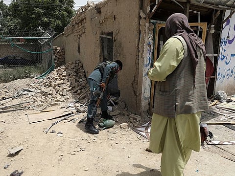 Afghan security personnel inspect the site of a bomb explosion in Kabul, on July 10, 2021.