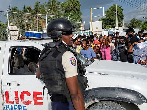 Haitian National Policemen guard the entrance to the US Embassy as people gather to ask for asylum following the assassination of President Jovenel Moise, in Port-au-Prince, Haiti July 9, 2021.