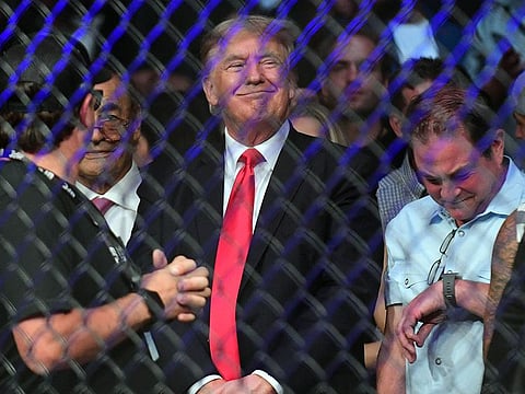 Former US President Donald Trump smirks as he is booed at UFC 264 at T-Mobile Arena