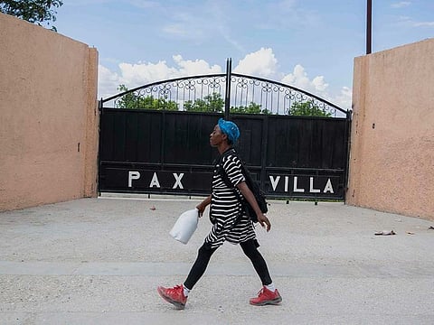 A woman walks past the entrance of the mortuary where the body of President Jovenel Moise was transferred to, in Port-au-Prince, Haiti, Saturday, July 10, 2021, three days after President Jovenel Moise was assassinated in his home .