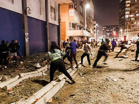 South Africa police stop looters in central Durban, on July 11, 2021. Several shops are damaged and cars burnt in Durban, following a night of violence.