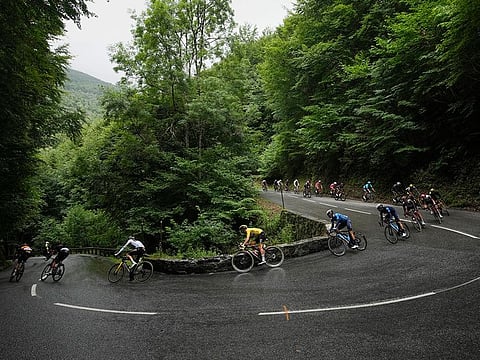 UAE Team Emirates' Tadej Pogacar, wearing the overall leader's yellow jersey, speeds downhill during Stage 16 of the Tour de France