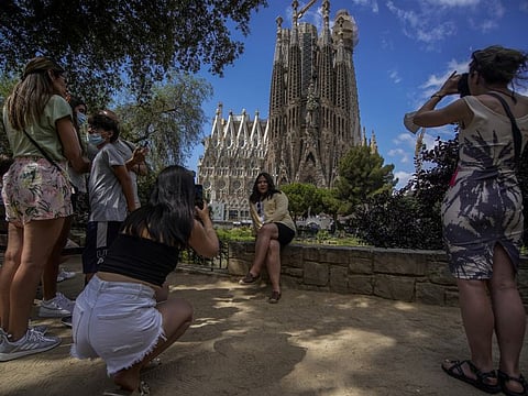 People take pictures in front of Sagrada Familia Basilica designed by architect Antoni Gaudi in Barcelona, Spain.