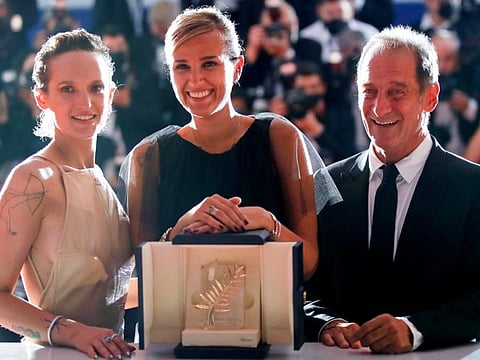 Director Julia Ducournau, Palme d'Or award winner for the film "Titane", poses with cast members Vincent Lindon and Agathe Rousselle.