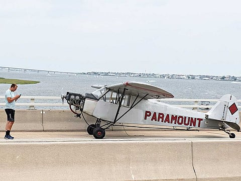 Landon Lucas, 18, a pilot flying for Paramount Air Service, stands next to his plane after he made an emergency landing on the Route 52 causeway connecting Ocean City and Somers Point, N.J. on Monday, July 19, 2021. No injuries were reported.