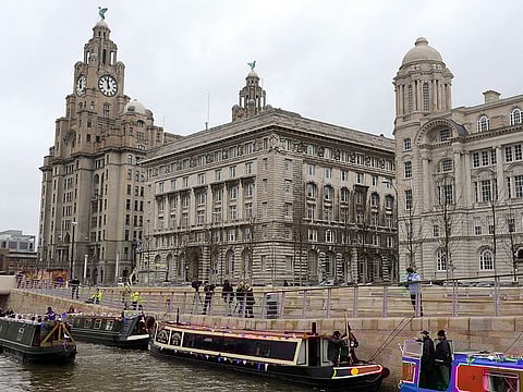 In this file photo, boats are moored up by historical waterfront buildings the Liver, Cunard and Port of Liverpool. Unesco on July 21, 2021 voted narrowly to remove Liverpool’s waterfront from its list of world heritage sites, citing concerns about overdevelopment including plans for a new football stadium.