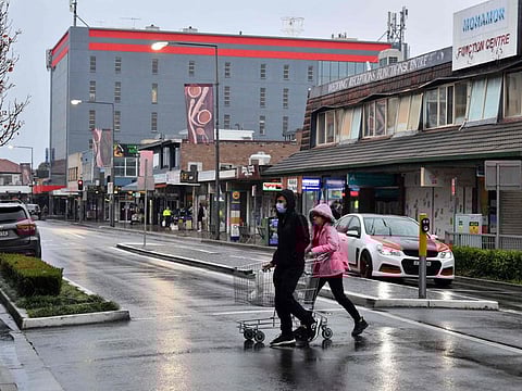 A couple make their way to a supermarket for last minute shopping ahead of new restrictions in the Fairfield suburb of Sydney in a file photo.