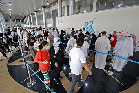 People queue up to receive a dose of a vaccine during the first day of the Eid at a vaccination centre in Kuwait City, on July 20, 2021.