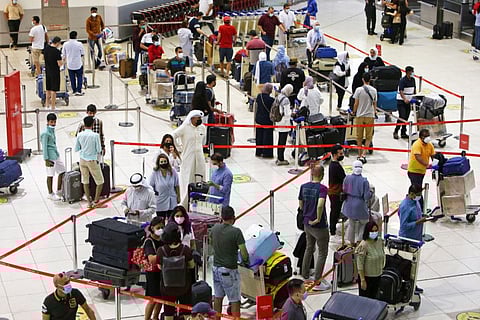 Passengers queue at the check-in counters at Kuwait International Airport.