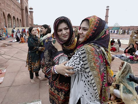Women greet each other after Eid Al Adha prayer at the historical Badshahi mosque in Lahore on July 21, 2021. The government has approved a law ensuring women’s property rights and their protection against harassment/coercion