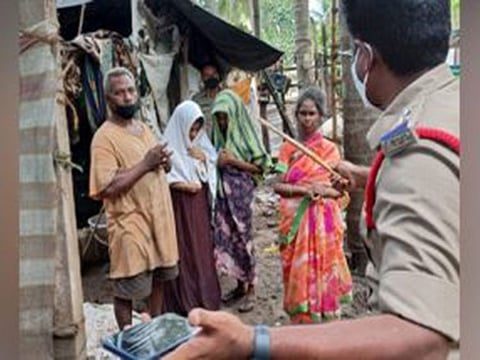 A policeman speaks to the family after they were 'freed' from the tent house.