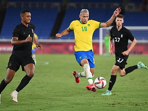 Brazil's hattrick man Richarlison (yellow) makes his way against Germany during their Tokyo 2020 Olympic Games men's Group D match at the Yokohama International Stadium in Yokohama on Thursday.