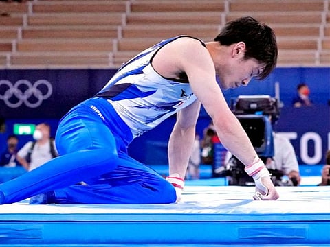 Kohei Uchimura of Japan reacts after his fall off the high bar in the Men's Gymnastics - Qualification Subdivision 2 during the Tokyo 2020 Olympic Summer Games at Ariake Gymnastics Centre.