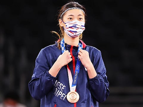 Lo Chia-Ling of Taiwan celebrates winning bronze in the Women's Taekwondo Featherweight 49-57kg event. Some medalists ignored the order from organizers to wear masks for the entire podium ceremony but now the IOC is easing restrictions.