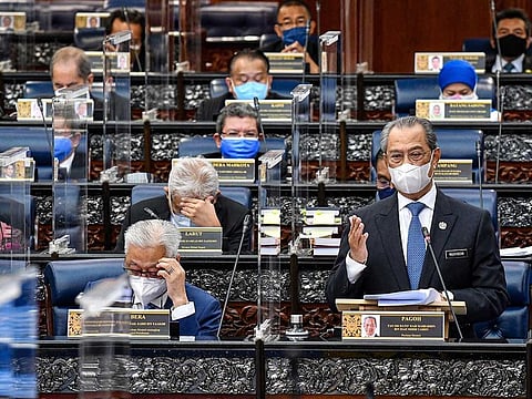 In this photo released by Malaysia's Department of Information, Malaysia's Prime Minister Muhyiddin Yassin wearing a face mask to help curb the spread of the coronavirus speaks at the parliamentary session at parliament house in Kuala Lumpur, Monday, July 26, 2021. Malaysia's government said it will not extend a coronavirus emergency beyond August 1 as Parliament reopened Monday after a seven-month suspension amid a worsening pandemic.