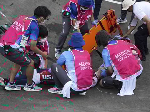 Connor Fields of the US, the defending gold medalist, is treated on the track after crashing during a men's BMX semifinal heat at the 2020 Tokyo Olympics, at the Ariake Urban Sports Park in Tokyo.