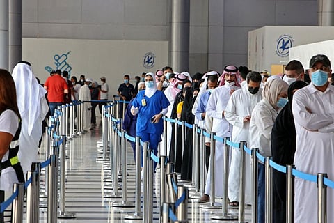 People queue up to receive a dose of a vaccine in Kuwait City in a file photo.
