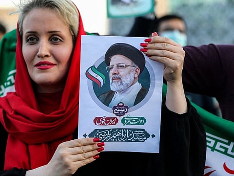 In this file photo taken on June 19, 2021 a woman holds a picture of Iran's newly-elected president Ebrahim Raisi as supporters celebrate his victory in Imam Hussein square in the capital Tehran.