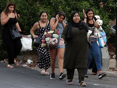 People flee their houmes after heavy clashes in the coastal town of Khaldeh, south of Beirut, Lebanon, on August 1, 2021.