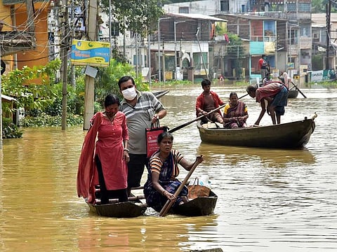 Local residents use boats to cross the waterlogged street due to a flood following the overflow of the Shilaboty river and the Kangshaboti river, in Ghatal, West Bengal, on Monday, August 2, 2021.