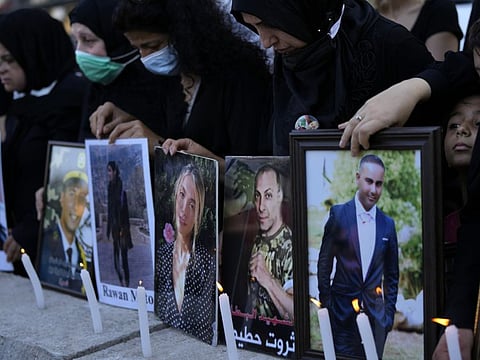 Relatives of victims of the August 4, 2020 Beirut port explosion hold portraits of their loved ones, in Beirut, Lebanon, on July 4, 2021.