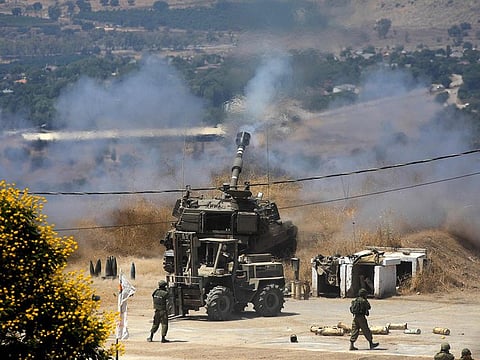 Israeli self-propelled howitzers take position in the northern town of Kiryat Shmona following rocket fire from Lebanon, on August 4, 2021.