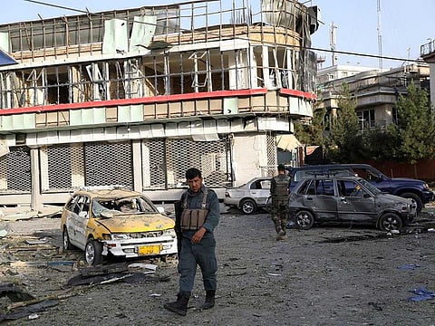 An Afghan security personnel walks around debris following an attack in Kabul, Afghanistan, Wednesday, Aug. 4, 2021. A powerful explosion rocked an upscale neighborhood of Afghanistan's capital Tuesday in an attack that apparently targeted the country's acting defence minister.