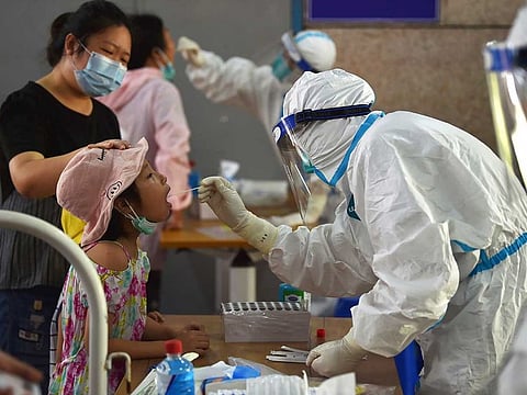 A nurse takes swab samples in new rounds of COVID-19 testing in Nanjing in eastern China's Jiangsu province Monday, Aug. 2, 2021.