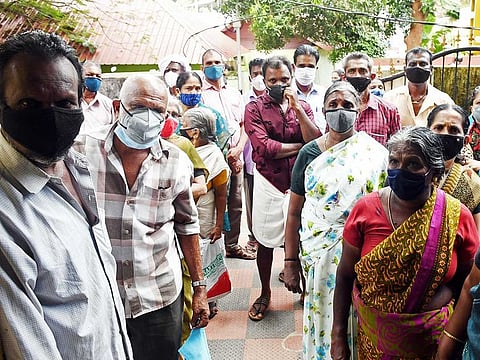 People wait to receive a dose of COVID-19 vaccine at a vaccination centre in Thiruvananthapuram.