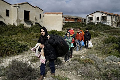 Afghan refugees walk through a beach where they will wait to board a dinghy sailing off for the Greek island of Chios, while they try to travel from the western Turkish coastal town of Cesme, in Izmir province, Turkey, in a file photo.