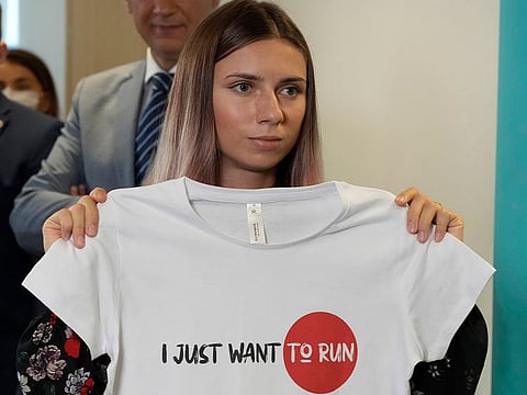Belarusian Olympic sprinter Krystsina Tsimanouskaya, who came to Poland Wednesday fearing reprisals at home after criticizing her coaches at the Tokyo Games, is showing an Olympic-related T-shirt with her slogan “I Just Want to Run” after her news conference in Warsaw, Poland, on Thursday, Aug. 5, 2021.